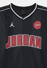 Black sports jersey with white and gray striped collar, large red "JORDAN" text, white Jumpman logo, and red circular "Flight" patch.