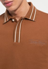 Brahma polo krekls ar teksturētu audumu, ar baltām svītrām uz apkaklītes un ar izšūtu logo uz krūšu vietas. Klasiskā piegriezumā.