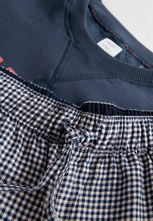 Marineblå sweatshirt med ribbet halsudskæring, kombineret med ternede pyjamasbukser med elastisk talje og snøre.