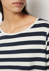 Marinblå och vit randig skjorta, tillverkad av mjukt tyg, med en vid halsringning och korta ärmar. Synlig slät textur och sömmar.