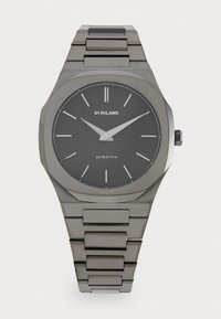 Montre ultrafine en acier inoxydable avec un cadran noir mat, des index d'heure minimalistes et un bracelet à maillons dans des tons métalliques assortis.