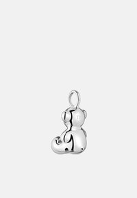 Charm de osito de peluche de plata con un acabado brillante, formas redondeadas, logo grabado en la parte posterior y un lazo para sujeción.