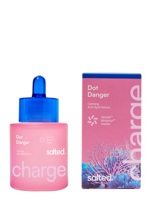 Pink dropper bottle and matching box of Dot Danger Calming Anti-Spot Serum by salted with blue cap and coral design on box.
