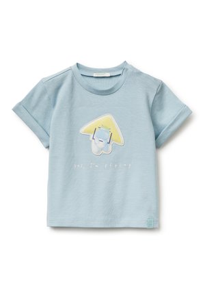 Maglietta per bambino piccolo a maniche corte di colore azzurro chiaro con un personaggio dei cartoni che vola sotto un aeroplanino di carta giallo e la scritta "sì, sto volando" sul davanti.