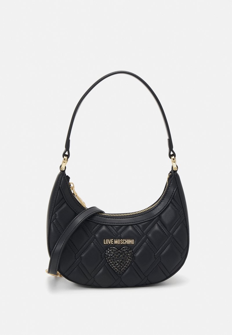 Black quilted handbag with a curved shape, featuring a gold zipper and a heart accent. The strap is adjustable for versatility.