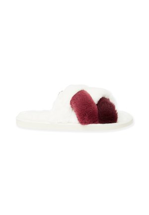 Chaussons blancs doublés de fourrure avec des accents en peluche bordeaux, une semelle plate et un design à bout ouvert, adaptés à une utilisation intérieure.