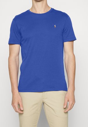 Niebieska bawełniana koszulka z okrągłym dekoltem i krótkimi rękawami, z małym haftowanym logo na lewej piersi. Dopasowany krój.