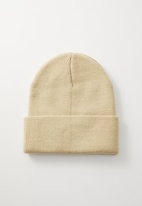 Beige kötött sapka hajtogatott szélekkel, sima textúrával és egyszerű, lekerekített tetejű kialakítással. Alkalmas hétköznapi viseletre.