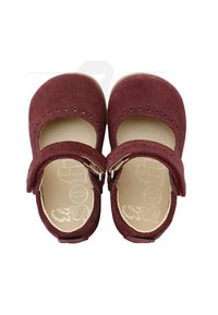 Zapatos Mary Jane en ante burdeos, con punta redonda, correa ajustable y detalles perforados en la pala. Plantilla suave.