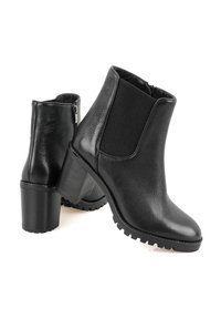 Bottines noires avec une tige en cuir texturé, un panneau latéral élastique, un talon épais et une semelle robuste pour une meilleure traction.