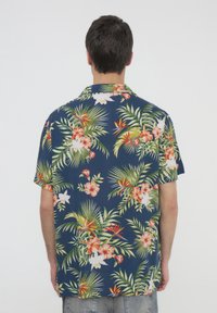Camicia a maniche corte di colore blu navy con vivaci motivi floreali e fogliari, caratterizzati da tonalità di rosso, bianco e verde. Tessuto leggero con una vestibilità comoda.
