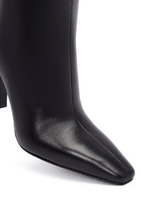 Bottine noire avec un bout pointu, en cuir lisse, avec un petit talon carré de hauteur intermédiaire et des détails de couture subtils.