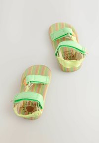 Gestreifte Babysandaletten in Pastellfarben mit grünen Riemen. Ausgestattet mit Klettverschluss und einer gepolsterten Innensohle für Komfort.