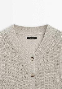 Cardigan tricoté gris clair avec un col rond côtelé et deux boutons brillants visibles sur le devant.