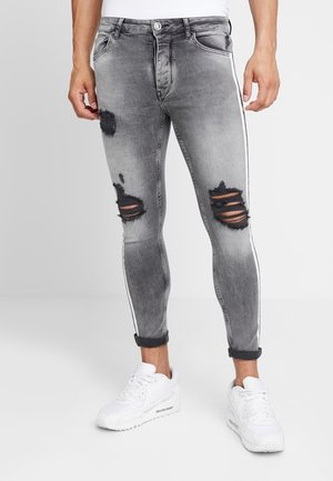 Grijze gescheurde skinny jeans met witte zijstrepen, voorzien van versleten gebieden en een taps toelopende pasvorm, gecombineerd met omgeslagen boorden.