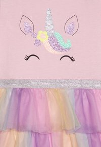 Abito rosa chiaro con un design di unicorno luccicante, con capelli iridescenti e accenti argentati, gonna a strati in tulle dai toni pastello.