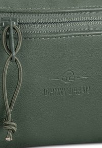 Pouch in ecopelle verde con zip, presenta una finitura testurizzata e una corda decorativa. Il logo in rilievo "JOHNNY URBAN" è visibile sulla superficie.