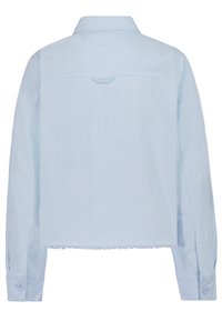 Světlemodrá džínová bunda s třepeným lemem, manžetami na knoflíky a zadním sedlem. Má klasický límeček a dlouhé rukávy.