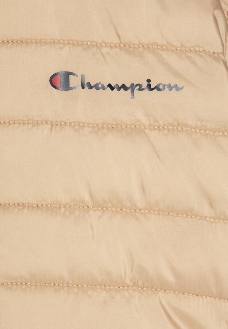 Beżowa kurtka puchowa z pikowanym wzorem. Posiada wyraźne metalowe logo "Champion" w kolorach niebieskim i czerwonym z przodu.