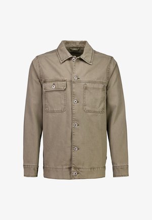 Veste en denim beige à manches longues, devant boutonné, deux poches poitrine—une avec rabat à bouton, l'autre ouverte.