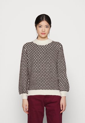 Knitted sweater featuring a brown and ivory diamond pattern, a cream ribbed collar, wide sleeves, and a fitted bottom hem.