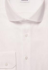 Camicia bianca con un motivo testurizzato, colletto classico, bottoni visibili lungo il davanti e un colletto interno etichettato "seidensticker."