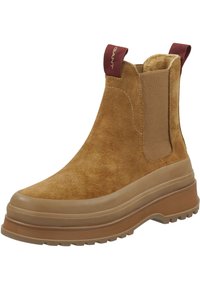 Bruine nubuck enkellaarzen met elastische zijpanelen en een pull tab, voorzien van een dikke rubberen zool met een gestructureerd patroon voor grip.