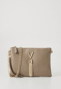 Béžová kožená kabelka do ruky se zlatým řetízkem, zdobená dekorativní střapcem a V-ks tvarovaným kovovým detailem na přední straně.