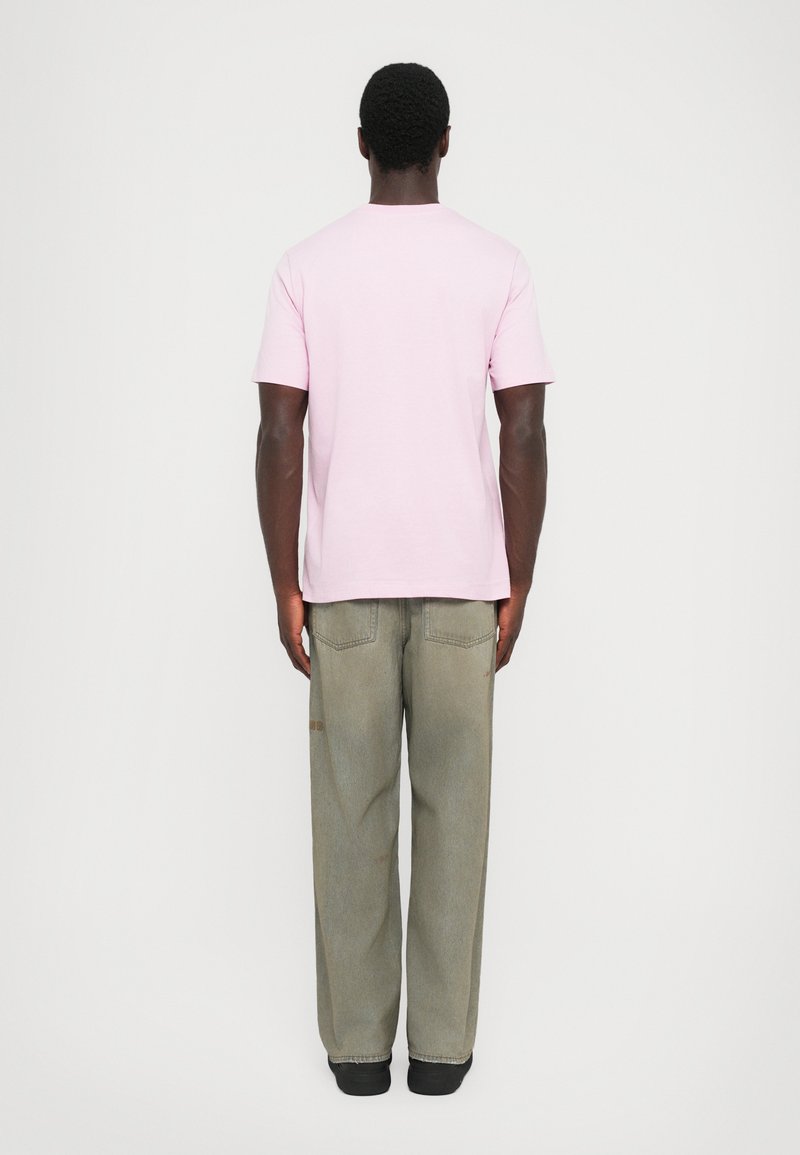 Light pink cotton t-shirt with short sleeves, paired with loose-fitting gray denim jeans featuring visible stitching and subtle distressing.