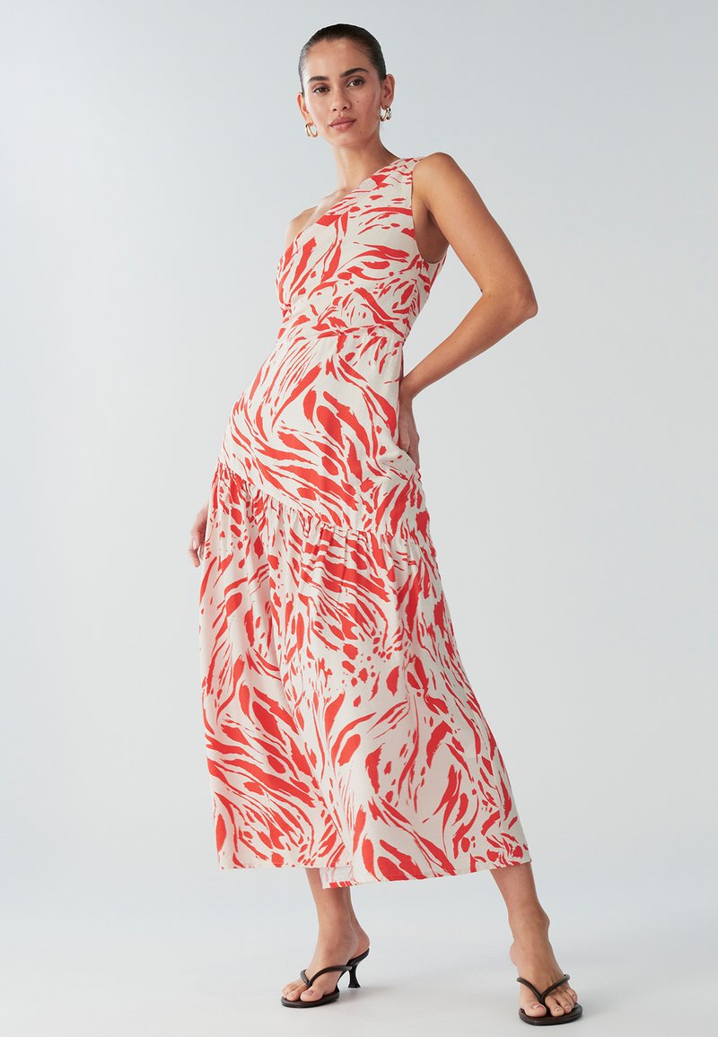 Maxikleit punase ja valge keerleva mustriga, millel on ühe õla disain, talje sisse tõmmatud ja astmelise seelikuga. Sile kanga tekstuur.