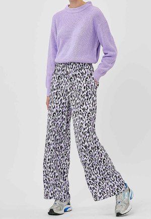 Lilla strikket sweater med ribbet tekstur kombineret med vidde bukser med et sort og lavendel abstrakt print. Sneakers fuldender looket.