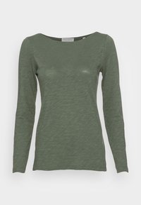 Langdurig shirt van zachte, textuur stof in olijfgroen, met een bootnek en een aansluitende snit met subtiele rek.