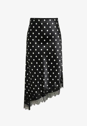 Jupe midi en satin noir à pois blancs, ourlet asymétrique et bordure en dentelle noire en bas.