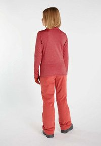 Rode longsleeve top met een ronde kraag en bijpassende koraalkleurige broek. De stof lijkt zacht met een gestructureerde afwerking, geschikt voor buitenkleding.