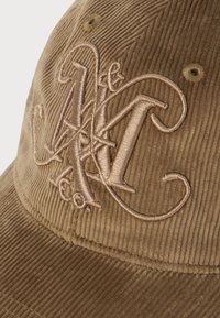 Brun kordfløjsp cap med hævede broderede stiliserede bogstaver "N&K Co." på frontpanelet.