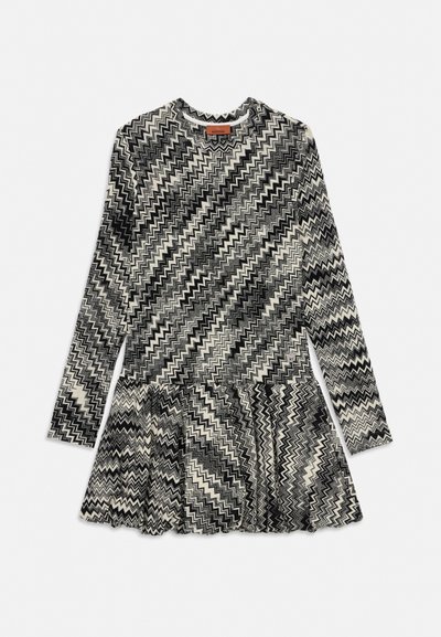 Abito a maniche lunghe con motivo a zigzag bianco e nero, scollo rotondo e orlo arricciato.