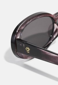 Purple marbled sunglasses with dark lenses, glossy finish, and a black frame. Features gold logo detail on the side arm.