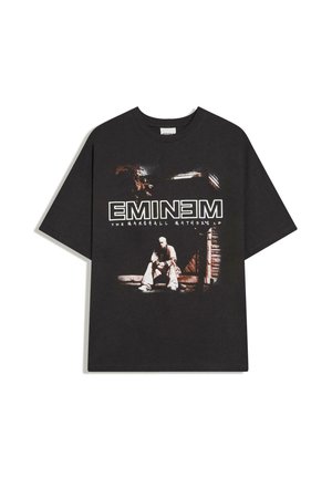 T-shirt noir à manches courtes avec un graphique d'un homme assis sur des marches et le texte "EMINEM THE MARSHALL MATHERS LP" en lettres blanches.