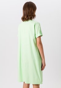 Mintgroene jurk met korte mouwen, een relaxte pasvorm, een zachte textuur en opgerolde manchetten, met zijzakken en een knielange zoom.