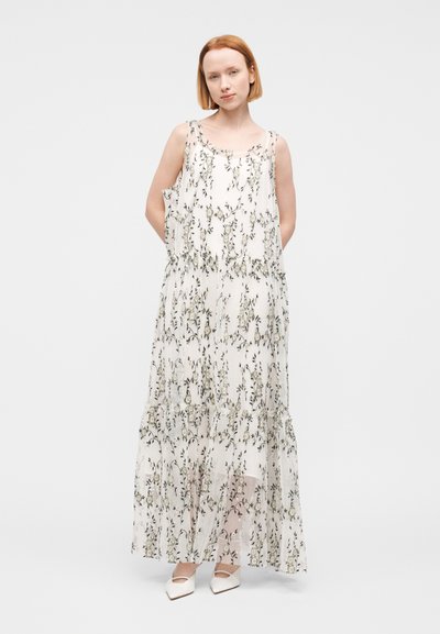 Robe longue en tissu léger et transparent, avec un motif floral vert et beige, dotée de bretelles réglables et d'une coupe à étages.