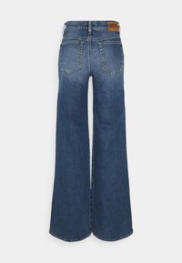 Wide-leg denim jeans in dark blue wash. Features a high waist, two back pockets, and a leather label with "Diesel" on the waistband.