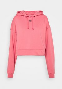 Różowa krótka bluza z kapturem wykonana z miękkiego materiału, z regulowanym kapturem na sznurki, prążkowanymi mankietami i małym czarnym logo na piersi.