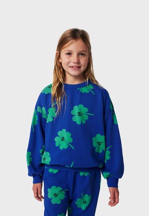 Blue pullover sweatshirt with oversized fit, featuring green clover patterns and black accents. Soft material and ribbed cuffs. Matching pants.