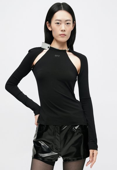 Fekete, hosszú ujjas felső, magas nyakkal, kivágott vállrészes dizájnnal és fényes fém részletekkel. Simogató, rugalmas anyag, amely testhez simuló fazont kínál.