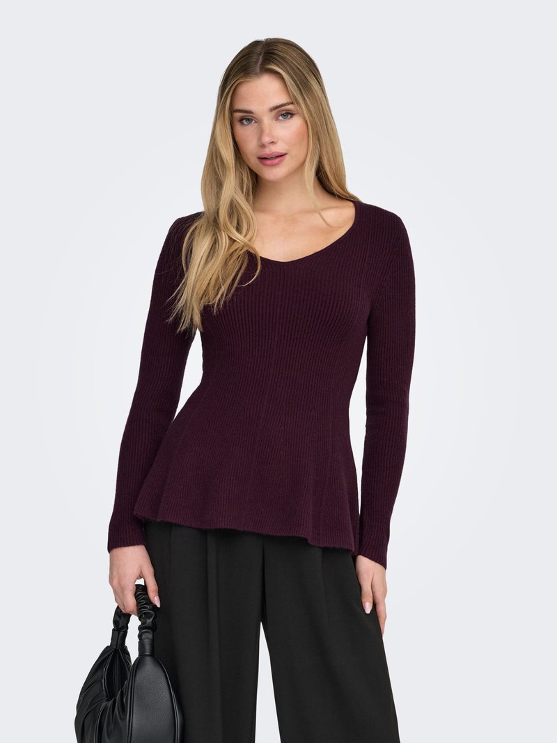 Pulover s V-izrezom i dugim rukavima od duboko burgundskog rebrastog pletenog materijala, s rasporenim rubom, uparen s hlačama visokog struka u crnoj boji i crnom torbicom.