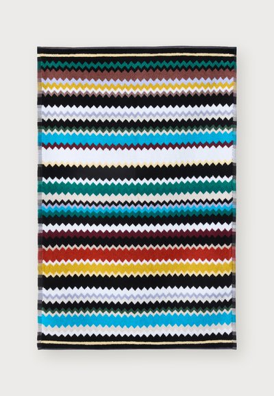 Mitmevärviline tekk, millel on teekonnad teal, mustas, valges, punases ja oranžis. Valmistatud tekstureeritud kangast, millel on elav disain.