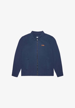 Veste bleu marine en coton avec un col, fermeture éclair sur le devant et deux poches latérales ; présente un petit patch en cuir marron sur la poitrine gauche.