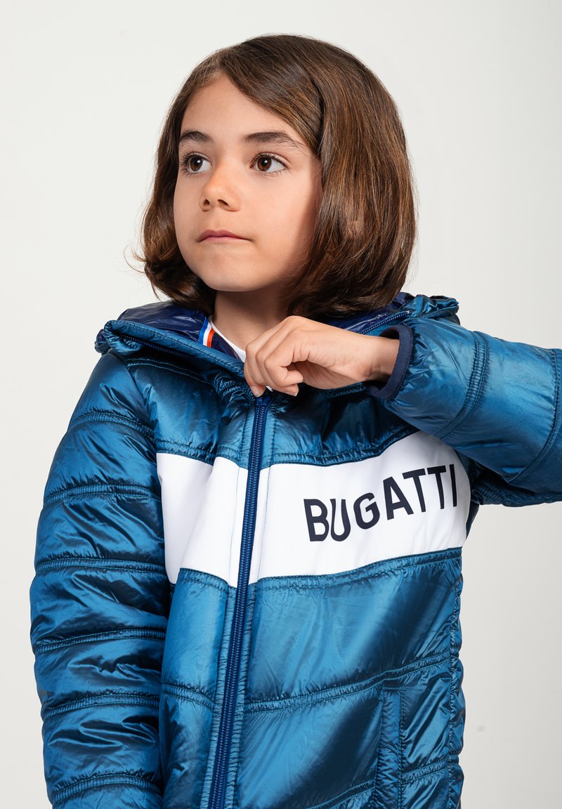 Giubbotto imbottito blu con finitura lucida, righe bianche, testo "BUGATTI" e chiusura con zip. Dotato di cappuccio e polsini elasticizzati.