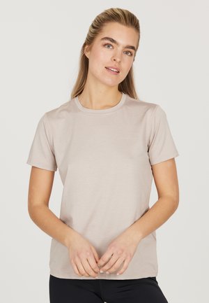 Lys beige kortærmet t-shirt, klassisk crew neck-design, blød bomuldsmateriale, minimal branding på brystet, glat tekstur.