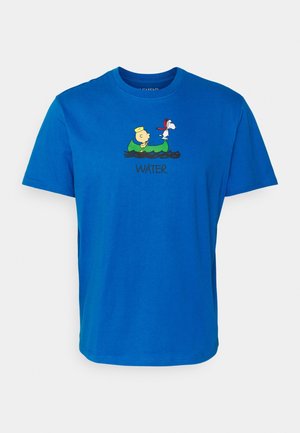 T-shirt bleu avec les personnages de dessin animé Charlie Brown et Snoopy dans un canoë vert sur l'eau avec le mot « EAU » en dessous.